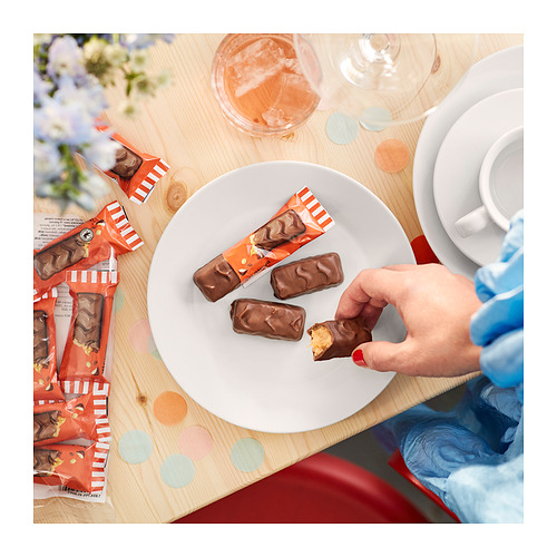 Recogida manual de chocolate BELÖNING del plato con más y tazas de té.