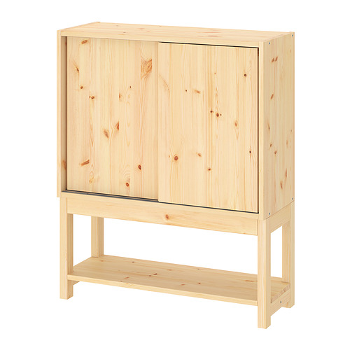 Mueble de madera clara IVAR con puertas correderas y estante inferior.