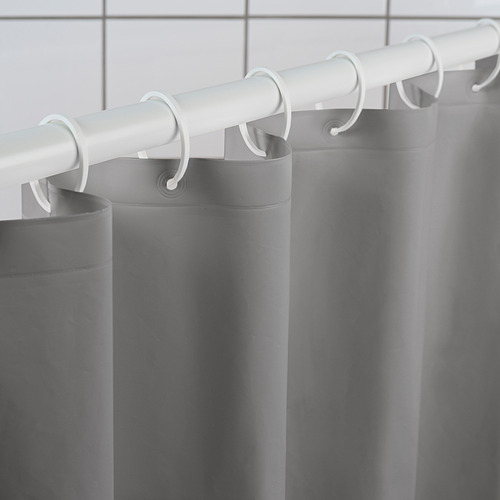 La cortina de ducha gris cuelga de ganchos y varillas blancas, lo que demuestra su diseño repelente al agua y duradero.