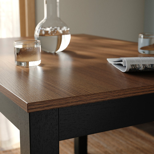 Mesa de comedor de madera con superficie lisa y pulida. Un impresionante acabado de chapa de fresno, que muestra patrones de vetas de madera natural.