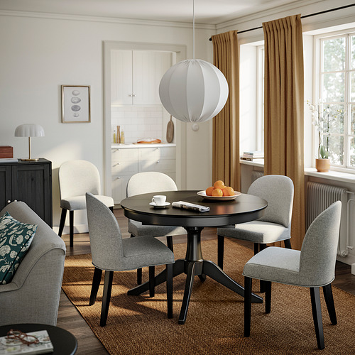 Comedor moderno con silla ROSENTORP en color beige-gris. Diseño suave y elegante alrededor de una mesa pequeña con lámpara.