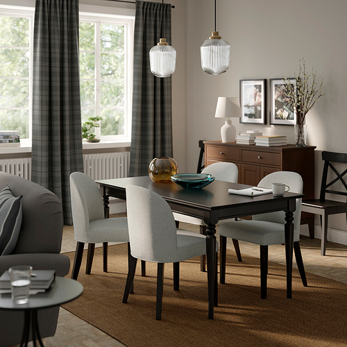 Acogedor comedor con sillas ROSENTORP, mesa, lámparas colgantes, cortinas grises, sofá y aparador.