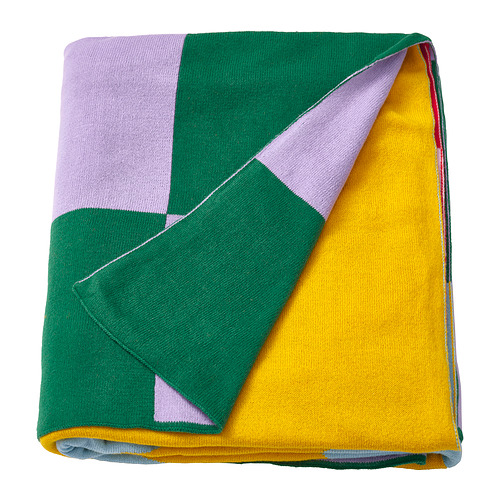 Manta GREJSIMOJS: colorido diseño geométrico, doblado con cuadrados verdes, amarillos y morados.