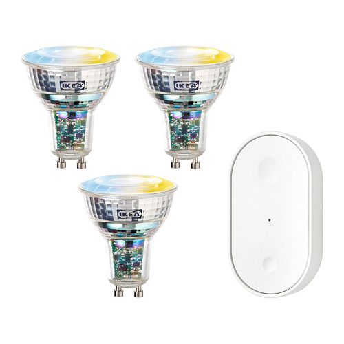 Tres coloridas bombillas inteligentes de ikea y un mando a distancia blanco.