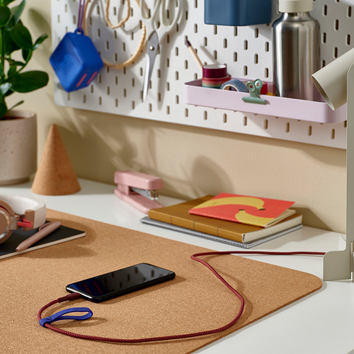 Escritorio bien organizado con carga del teléfono a través de un cable usb LILLHULT flexible con cabeza de goma. El cable se mantiene libre de enredos con su banda elástica.