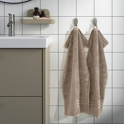 Baño moderno con toallas BROKGLIM, lavabo y espejo. Algodón orgánico, estante de artículos de tocador.