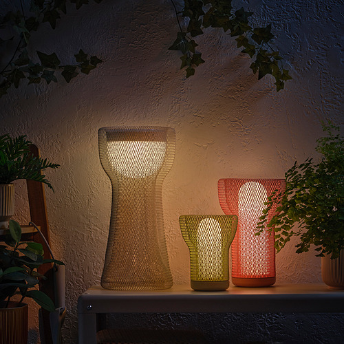 Tres luces decorativas en una estantería, iluminadas con plantas.