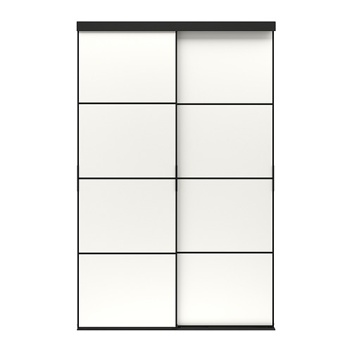 Una puerta corredera SKYTTA en color negro con paneles de vidrio esmerilado. El diseño moderno, un marco de aluminio anodizado y rieles de soporte de pino.