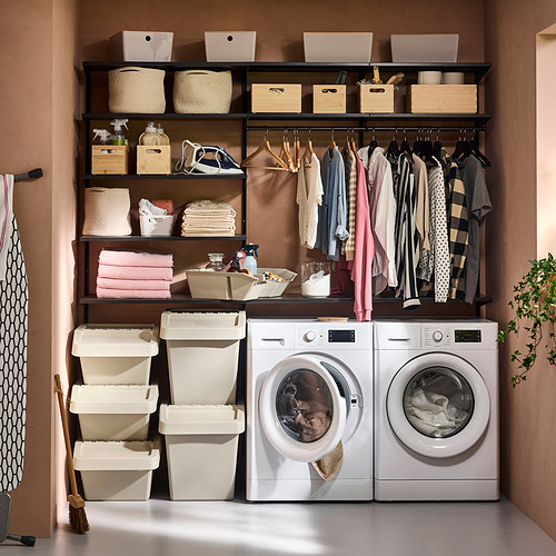 Lavandería organizada con lavadora, secadora, estantes y contenedores de clasificación.