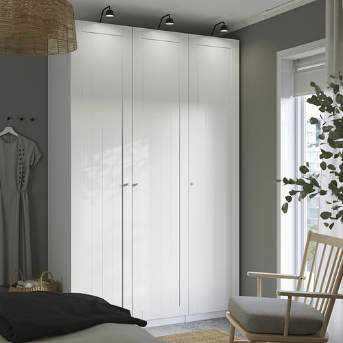 Dormitorio moderno con armario GULLABERG, madera clara, plantas, decoración minimalista.