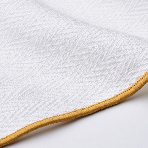 Tela blanca doblada con borde dorado