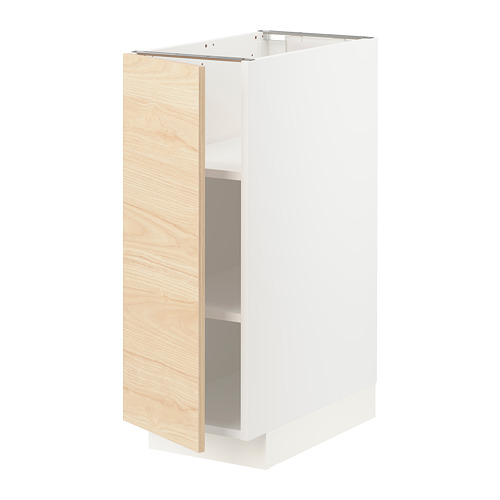 Un mueble de cocina METOD con puerta askersund con motivos de madera de fresno claro. Es un marco blanco y tiene un estante ajustable en el interior.