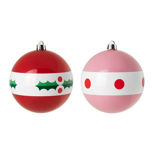 Adornos navideños rojos y rosas: uno con acebo, otro con lunares.