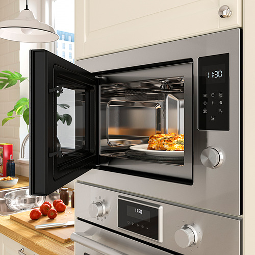 La imagen muestra un microondas abierto con comida dentro, mostrando la hora y varias cocciones.