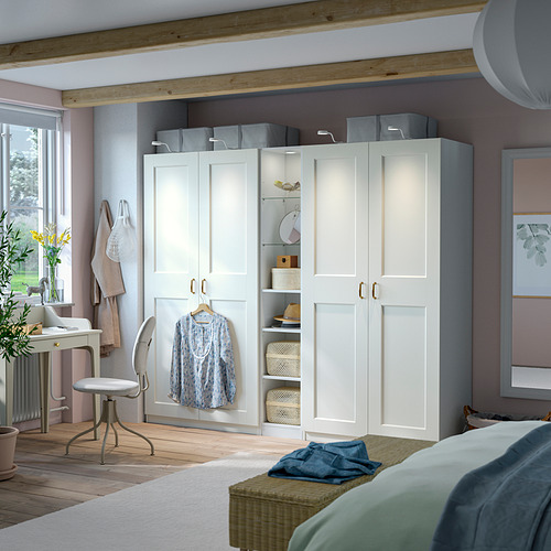 Dormitorio moderno con armario PAX blanco, almacenamiento mixto, cajas grises, camisa colgante, escritorio, cama, ropa de cama azul, piso de madera, luz natural.
