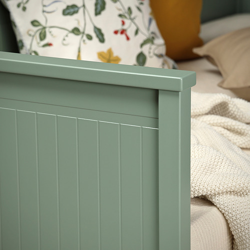 Sofá cama de madera verde salvia con ranuras verticales para un sofá elegante y acogedor y espacio adicional para dormir.