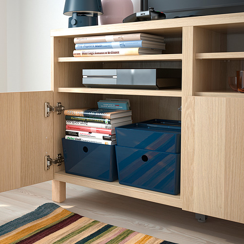 Armario de madera abierto con cajas de plástico azul y libros apilados, ideal para organizar y guardar objetos.