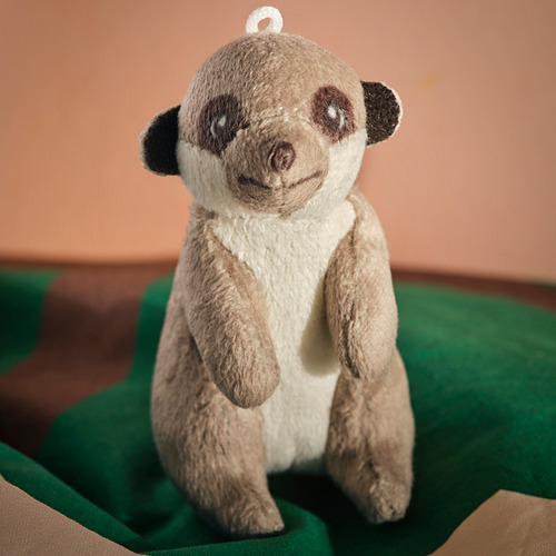 Panda de peluche en superficie verde, textura suave, materiales ecológicos.