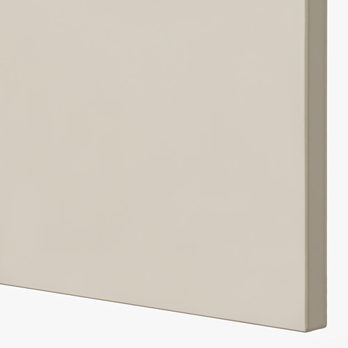 Primer plano de la puerta lisa de un armario de cocina beige de excelente calidad, que muestra una superficie lacada sin costuras.