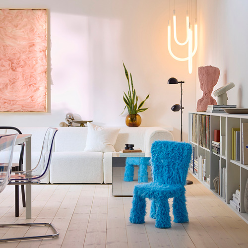 Salón moderno con silla infantil turquesa, poliéster reciclado, decoración minimalista, arte y luz de neón.