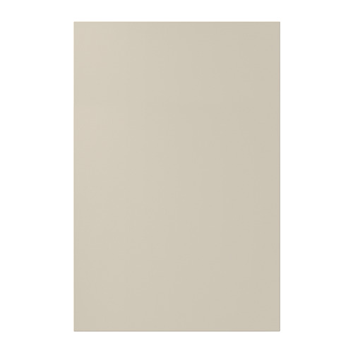 Una puerta de armario de cocina HAVSTORP beige. Tiene paneles lisos y un diseño moderno, elaborados con pintura acrílica y tableros de fibra.