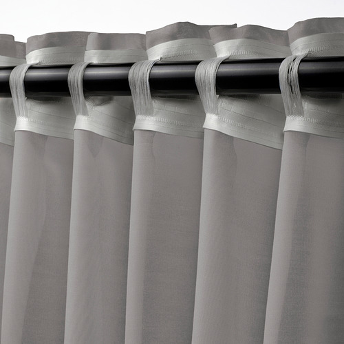 Cortinas transparentes STENFRÖ con parte superior de ojal, con tela transparente para difuminar la luz solar y la privacidad. Color gris con cinta de cabecera para facilitar el plisado.