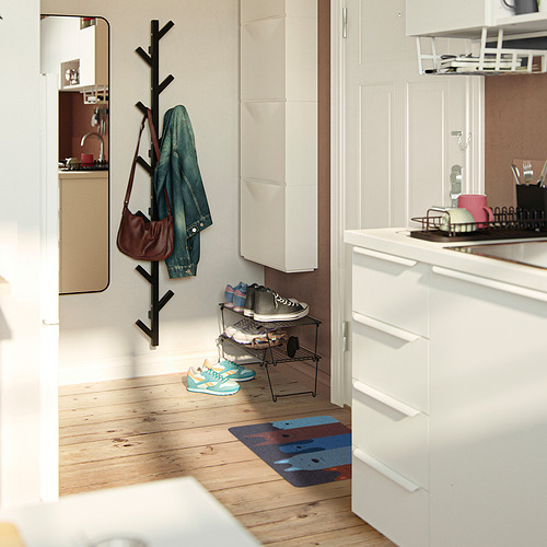 Entrada moderna con gabinetes blancos; Alfombra TURISTVÄG , colorida, rectangular, cabe debajo del zapatero; Chaqueta, bolso, zapatos en ganchos y estante.