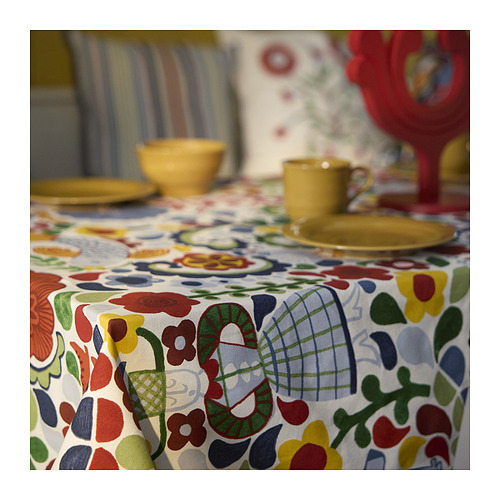 Mantel floral multicolor brillante con platos amarillos.