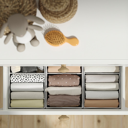 Cajón organizado con ropa doblada cuidadosamente en compartimentos. Incluye un kit de anclaje de seguridad.