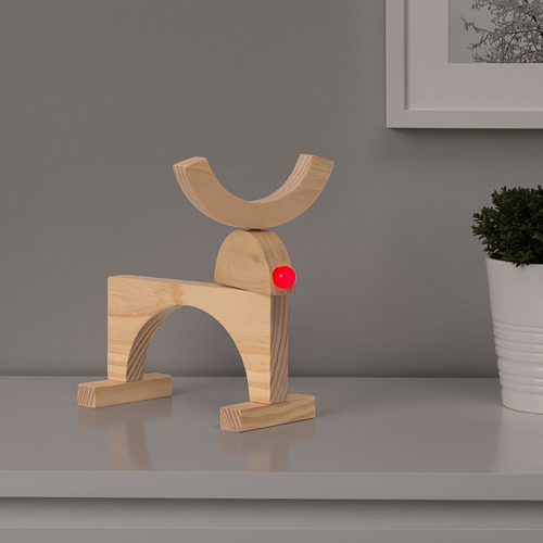 Lámpara moderna de madera con esfera roja en la parte superior, colocada sobre un estante gris.