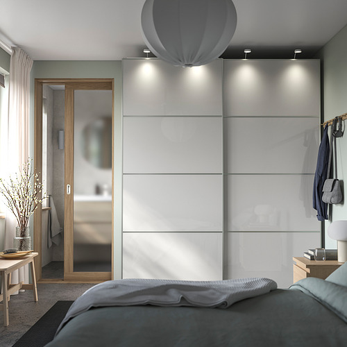 Dormitorio moderno con un elegante armario gris HOKKSUND de alto brillo, cama acogedora y una decoración elegante.