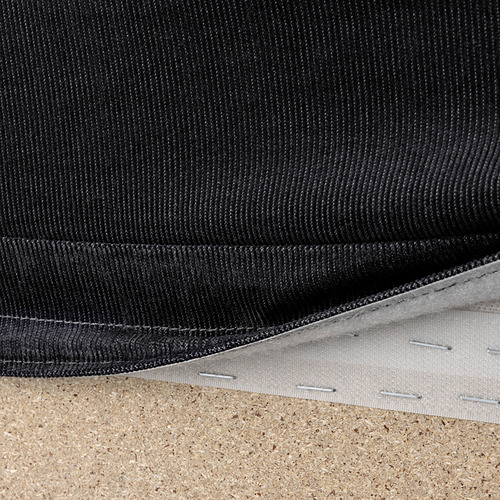 Tela de sofá negra con costuras y cremallera visibles, con funda extraíble para facilitar la limpieza.