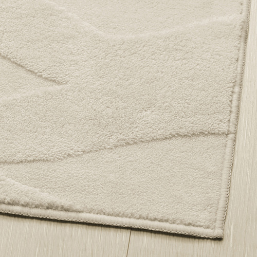 Primer plano de una alfombra suave y lujosa con patrón texturizado. Respaldo antideslizante, materiales 100% reciclados.