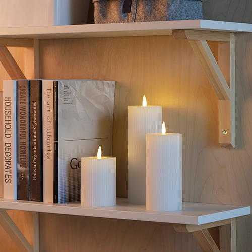 Estantería con libros y velas led. Las velas emiten un brillo cálido con función de temporizador.