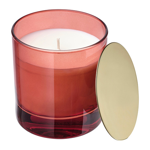 Vela VINTERFINT: vidrio rojo, tapa dorada, forma redondeada. Emite aroma a naranja y clavo.