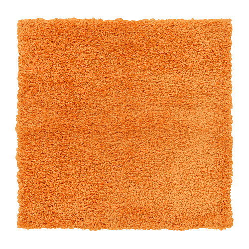 Una alfombra de área peluda rectangular naranja. Es suave, grueso y resistente a las manchas con un diseño liso.