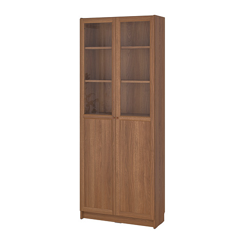 Estantería de madera BILLY con puertas de vidrio, que exhibe artículos y oculta el desorden.
