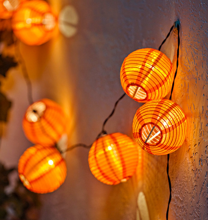 Guirnalda de farolillos de papel naranja que aporta luz cálida y ambiente acogedor a cualquier rincón del hogar.