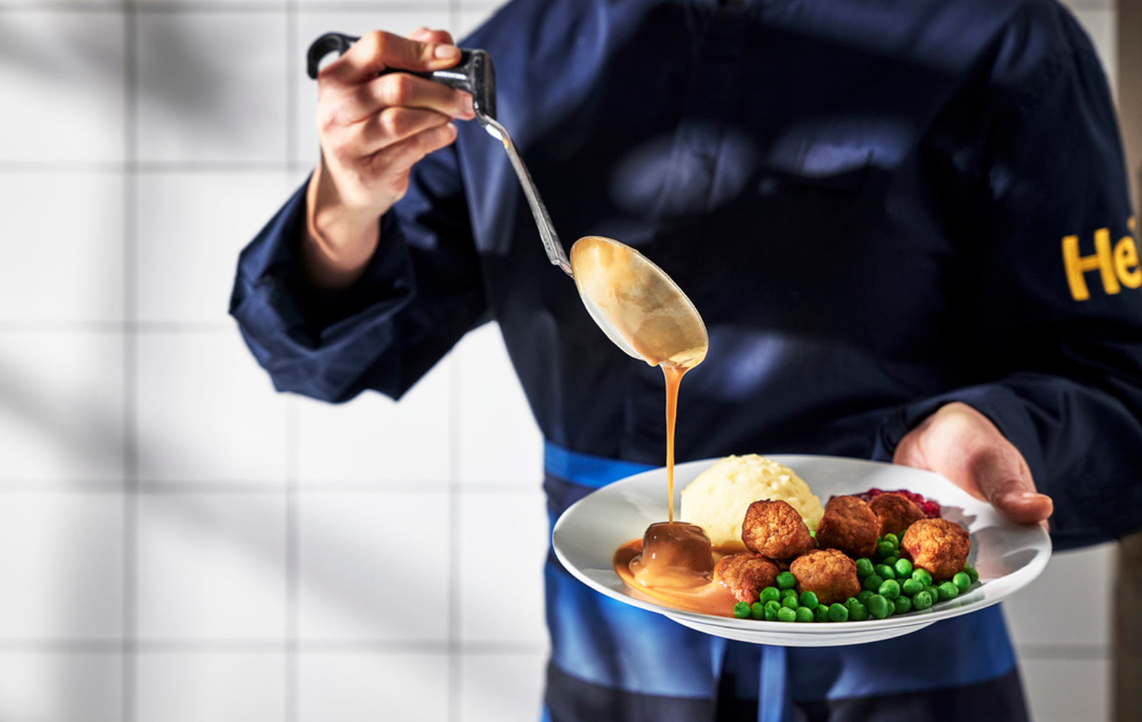 Chef bañando albóndigas de IKEA con salsa.