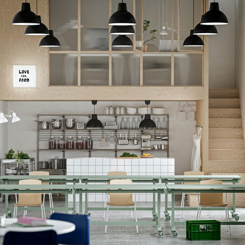 A workspace with event furniture, including green MITTZON foldable tables, LÄKTARE conference chairs, and open shelving.