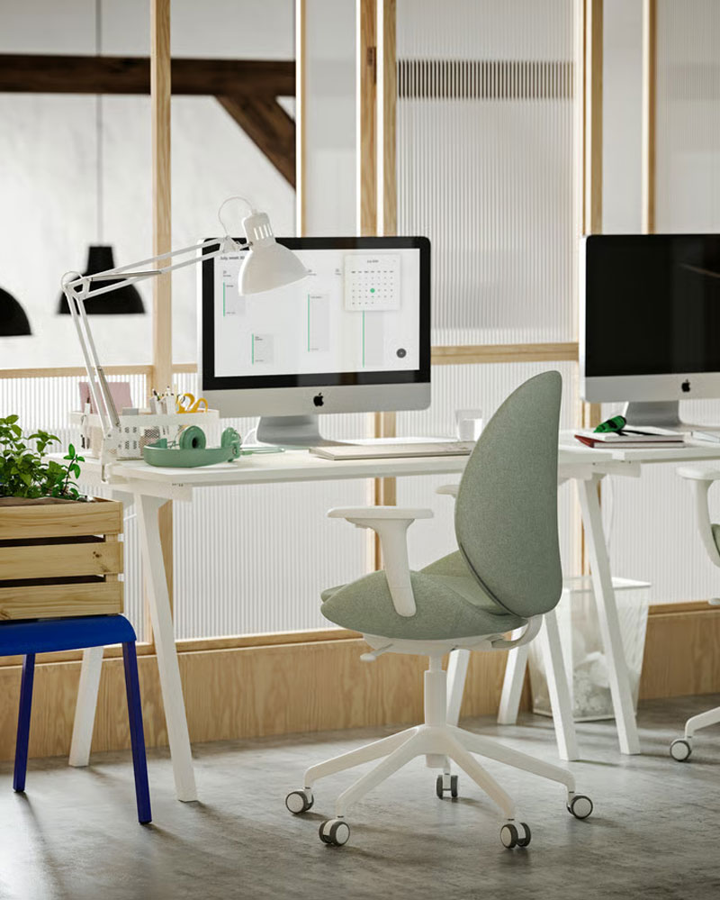 A small office with two white TROTTEN desks, light green/white HATTEFJÄLL conference chairs and white TERTIAL work lamps