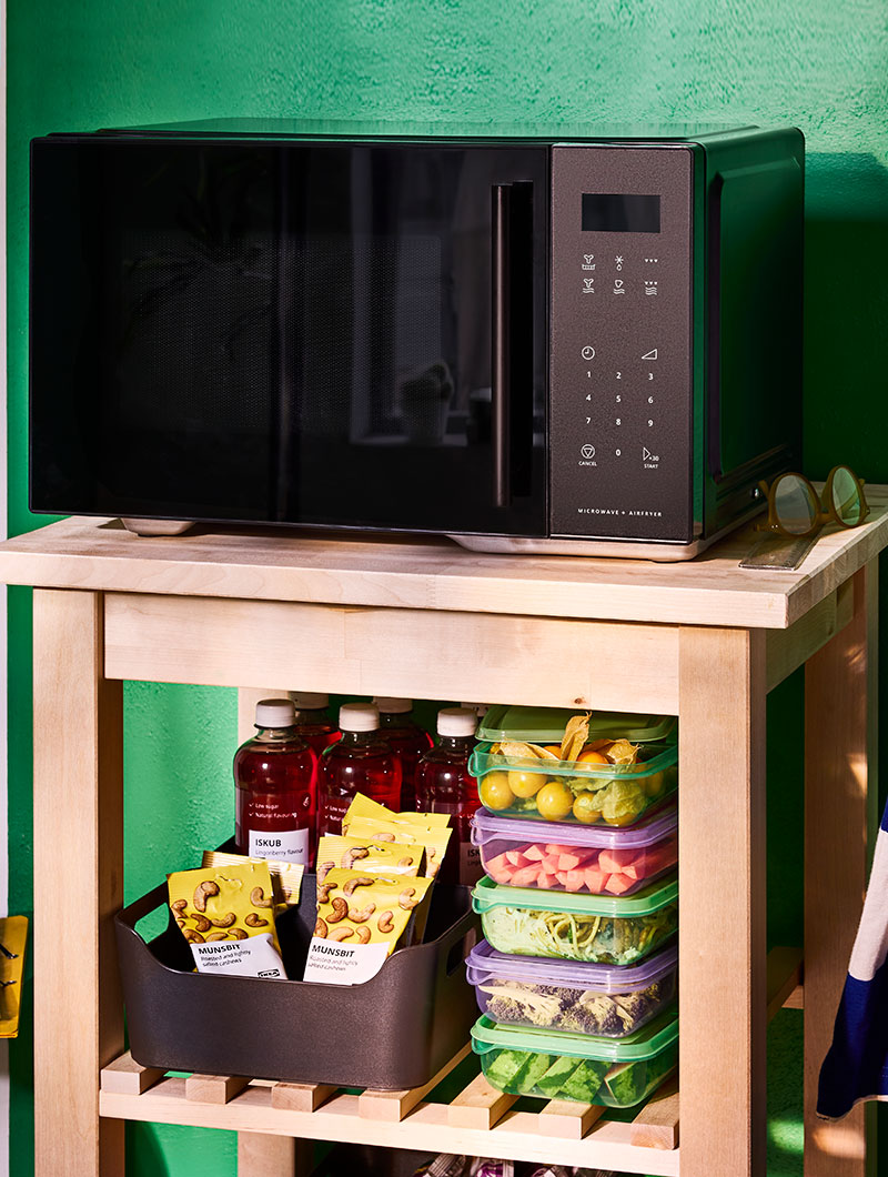 Freestanding GÅTEBO microwave oven/air fryer, a stack of purple and green PRUTA sandwich containers and ISKUB cashnew nuts