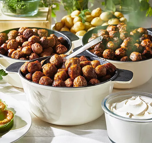 Tres grandes cuencos de carne o albóndigas vegetarianas cocinadas al vapor, acompañados de patatas cocidas y un tazón de salsa blanca, dispuestos sobre una mesa para servir.