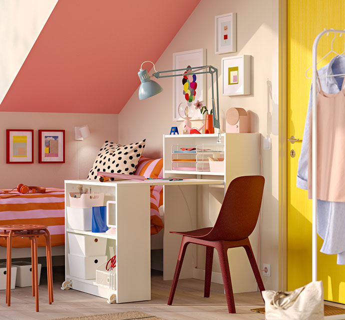 Dormitorio colorido con escritorio, cama a rayas y decoración alegre.