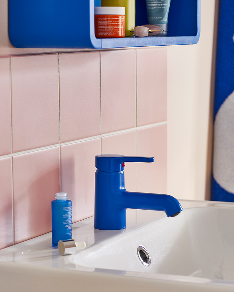 A washbasin with a blue BERGVATTNET washbasin mixer tap and a blue mirror cabinet mounted on the wall above