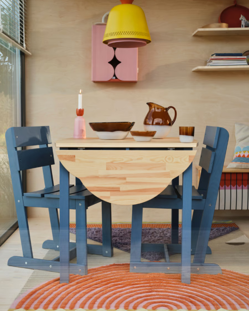 Mesita de madera con dos sillas de estilo tradicional en un ambiente industrial antiguo.