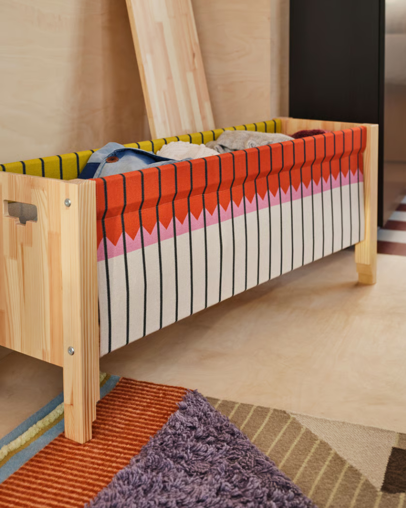 Banco de madera hecho a mano con la parte delantera abierta en colores otoñales, que deja ver los coloridos tejidos del interior.
