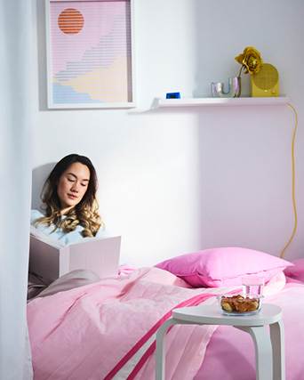 una chica leyendo un libro en su cama