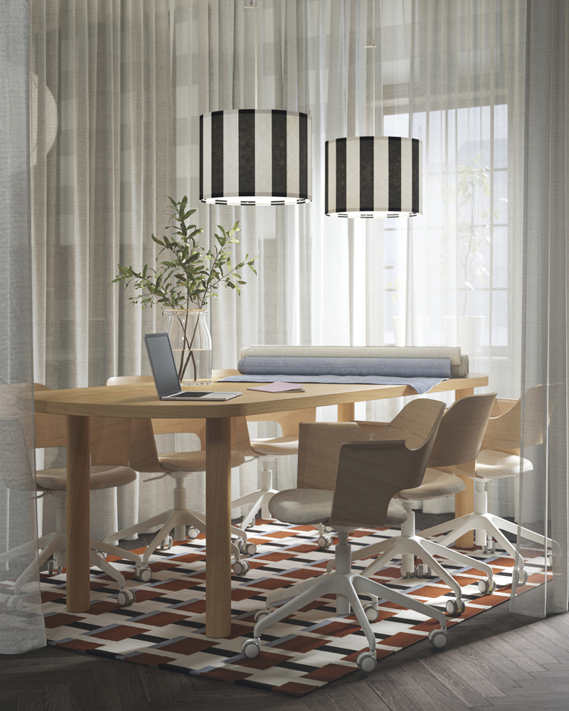 Un espacio de reuniones con cortinas blancas translúcidas ÄNGSFRYLE, una mesa STOCKHOLM de chapa de roble y sillas de conferencia acolchadas a su alrededor.