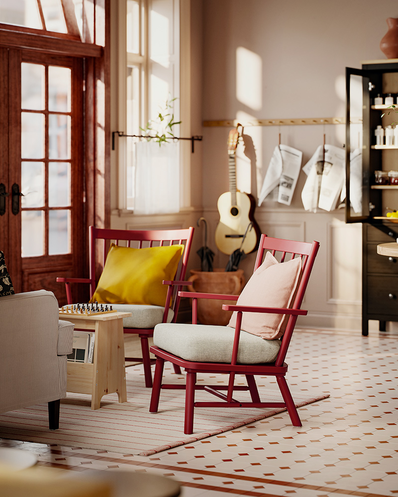 Una zona de recepción con baldosas cuenta con dos sillones con barrotes PERSBOL en tono marrón rojizo, con cojines de asiento beige gris, frente a una mesa y un sofá.